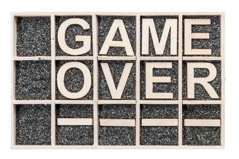 In a collecting box with black decorative sand arranged plywood letters the word GAME OVER stacked