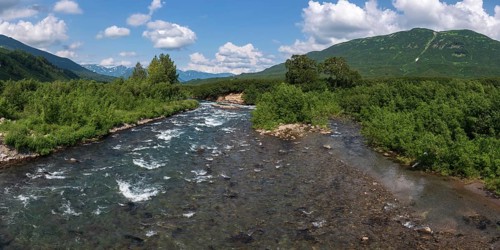 Stunning summer panoramic landscape of Kamchatka Peninsula: view of stream clear water of mountain
