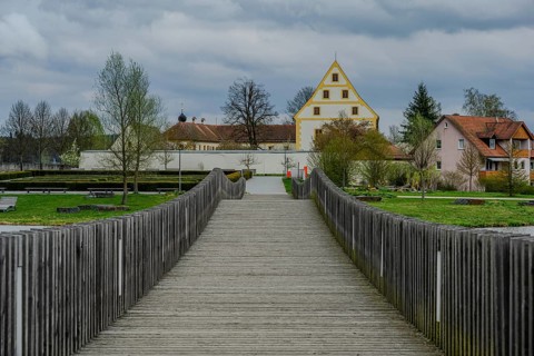 Wooden bridge leads to a historic building in a green park landscape, Tirschenreuth, Upper