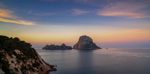 A panorama landscape view of the landmark Es Vedra island and rocks off the coast of Ibiza at