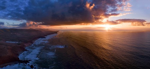 Aerial panorama of Legzira beach with arched rocks on the Atlantic coast at sunset in Morocco