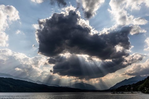 Cloudy mood over Lake Millstättersee, sunbeams from clouds, near Millstatt, Carinthia. Austria