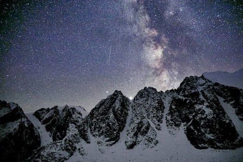 Milky Way and snowy mountains in Altai at night