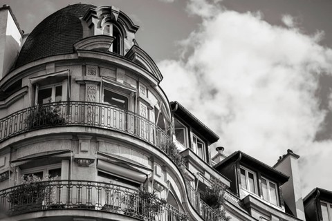 Details of a residential building with curved walls, balconies and ornate iron railings in Paris,