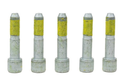 Five bolts for the car with the yellow glue on the threads. Isolate on white