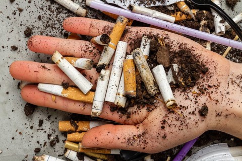 Close up hand holding pile of cigarettes with dirt. Concept of enviroment pollution