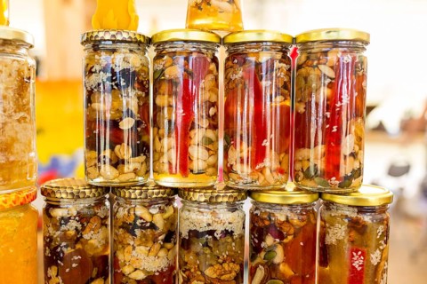 Honey with dried fruits and dried nuts - walnuts, hazelnuts, peanuts, almonds, cashews, plums,