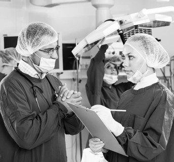 Portrait of surgeons in surgery with doctors working on background