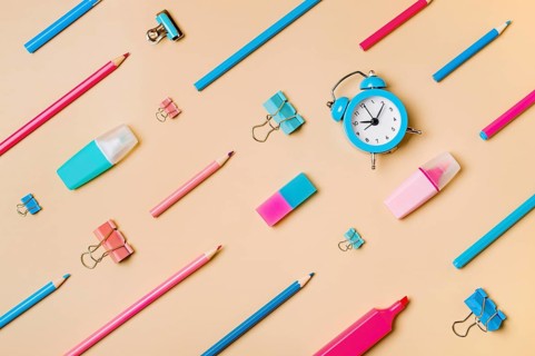 Creative student desk modern school supplies on neutral pastel beige background. Top view flat lay.