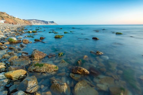 Stony sea beach of the 40th anniversary of the victory of the high coast of Anapa at sunset, Black