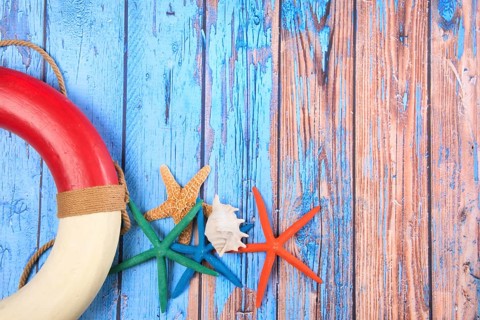 Beach poster on wooden background with starfishes and life buoy