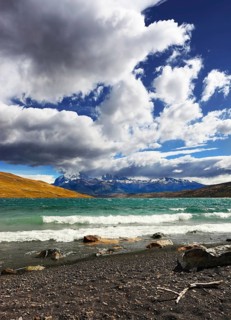 Stormy wind blows the clouds over the lake Laguna Azul. National Park Torres del Paine. Patagonia,