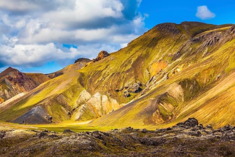 Travel to Iceland in the July. Summer volcanic tundra. Multi-colored mountains from mineral
