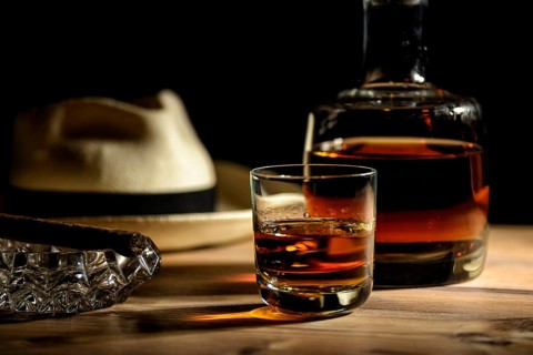 A glass of rum, a cigar and a Panama hat in a bar in Cuba