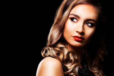 Beautiful woman with dark makeup and red lipstick posing on black background, Toronto, Canada,