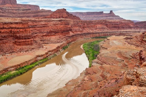 A jetboat transporting kayaks upstream of Colorado River below Moab in Utah