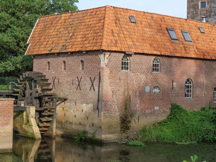 Detailed view of a brick watermill with water wheel and surrounding vegetation, winterswijk,