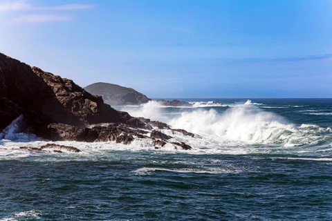 Huge waves of ocean surf beat against stone breakwaters. Magnificent Atlantic Ocean. Picturesque