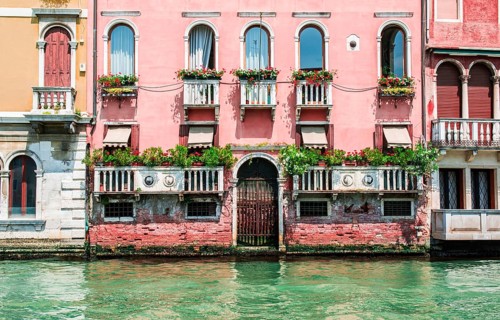 Ancient buildings in Venice. Boats moored in the channel. View from the side of the water