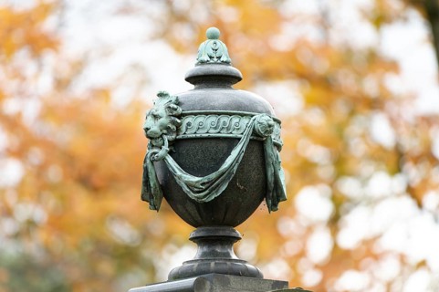 Ancient burial urn in a historic cemetery in autumn