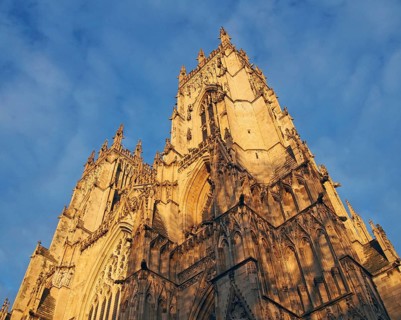 An upwards view of the towers at the front of york minster in sunlight