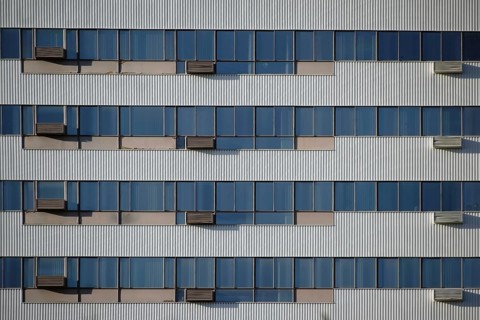 The modern façade and exterior wall of an office building with solar control windows and air