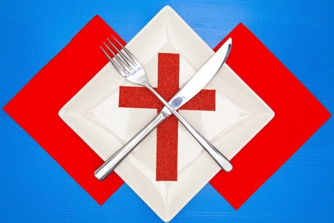 White square plate and red Christmas decoration on the blue wooden table.Top view.Flat Lay Image