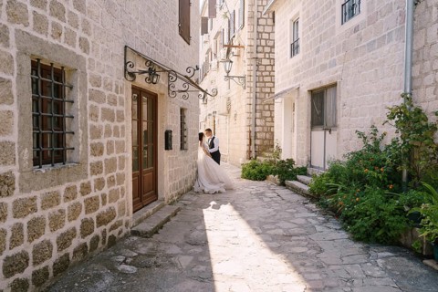 Wedding couple on the street of the old city, among ancient houses. Fine-art wedding photo in