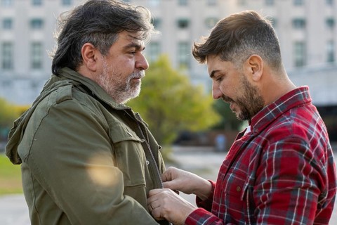 A man is adjusting his husband's jacket