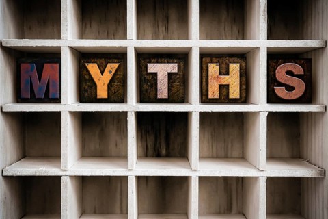 The word MYTHS written in vintage ink stained wooden letterpress type in a partitioned printer's