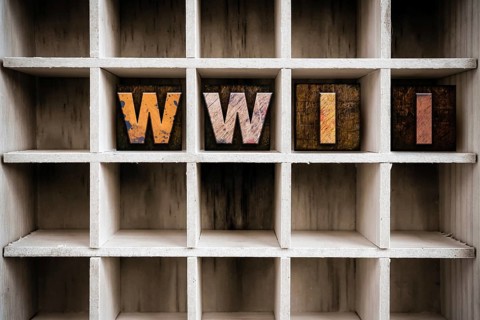 The word WWII written in vintage ink stained wooden letterpress type in a partitioned printer's