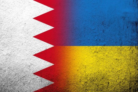 The Kingdom of Bahrain national flag with National flag of Ukraine. Grunge background