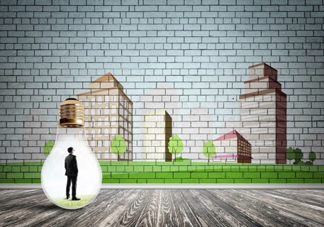 Businessman inside light bulb against city drawn concept