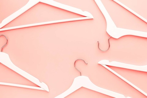 Creative top view flat lay wooden hangers toned living coral color of the year 2019 background copy