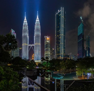 A picture of the Petronas Twin Towers as seen from the KLCC Park at night