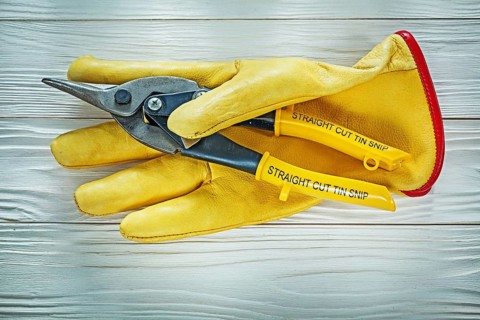 Protective gloves tin snip on wooden board
