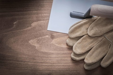 Protective gloves and plastering trowel construction concept