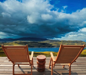 Two comfortable wooden sun loungers on the shore of the lake. Torres del Paine National Park.