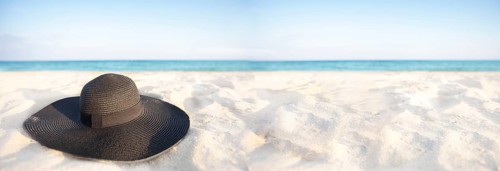 Banner Black hat on a background of the sea. Beach accessory on white sand. Straw panama on the