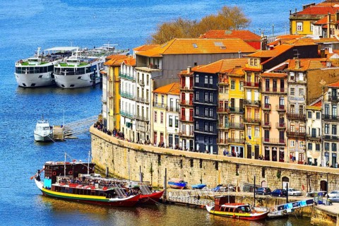 Porto, Portugal old town ribeira aerial promenade view with colorful houses, Douro river and boats