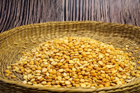 Brown bowl full of dry pea. Healthy eating and vegetarian concept