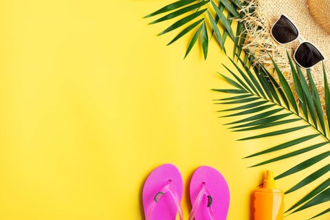 Vacation travel planning simple theme of straw hat sunglasses flip flops and palm leaves on uniform