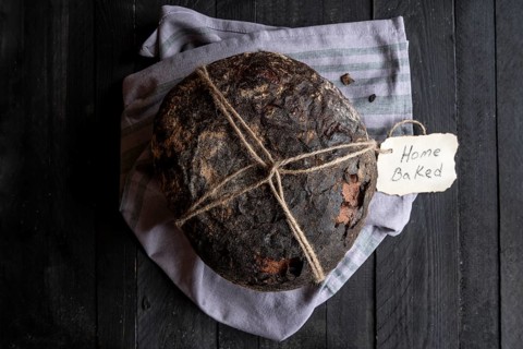 Fresh baked homemade bread on a black wooden table. Above view image