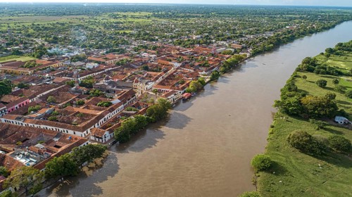 Aerial view of the historic town Santa Cruz de Mompox in sunlight with river and green
