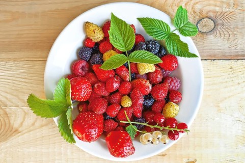 Strawberry, raspberry, blackberry, white and red currant, green leaves of strawberries and