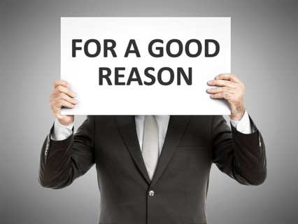 A business man holding a paper in front of his face with the message for a good reason