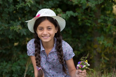 Girl with straw hat and bouquet of flowers