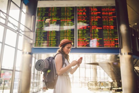 Theme travel and tranosport. Beautiful young caucasian woman in dress and backpack standing inside