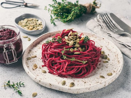 Beetroot pesto or hummus. Homemade beet pesto sauce in glass jar and fresh thyme on dark black