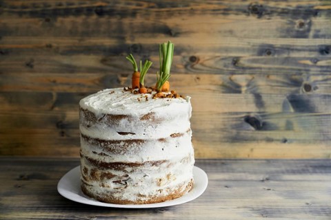 Carrot cake on a plate on wooden background.